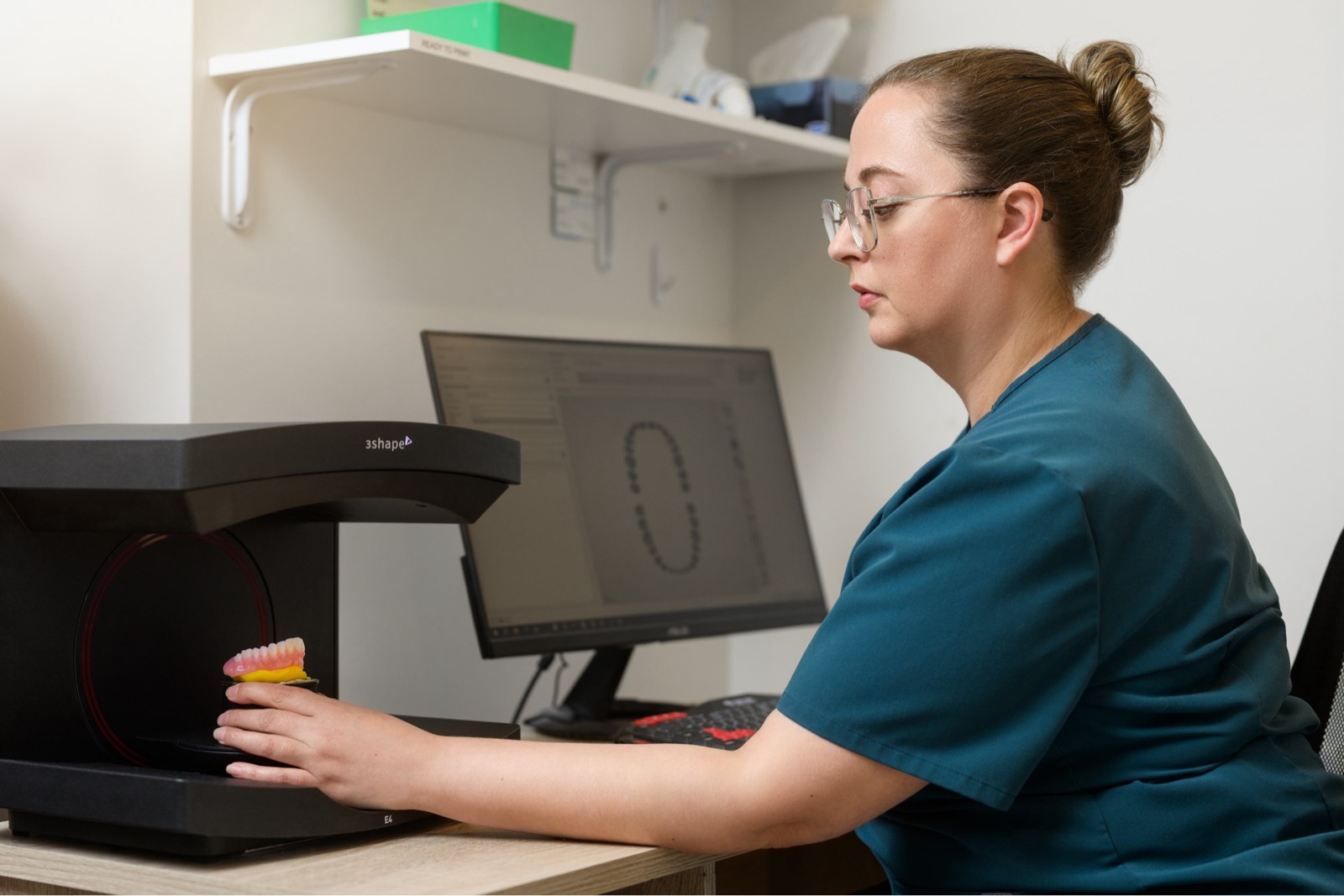 Dental assistant placing dentures into 3D scanner