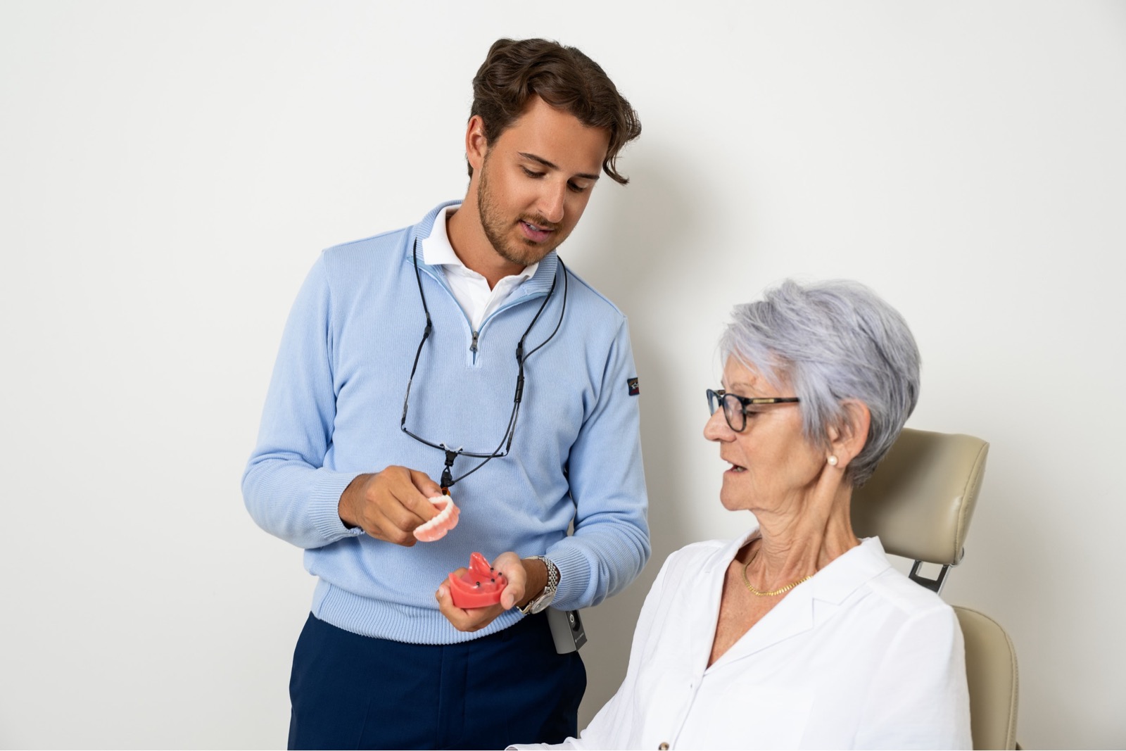 Denturist at Dieppe Denture clinic presenting new dentures to patient